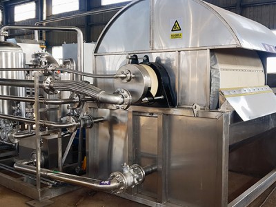 What are the advantages of vacuum drum filters in treating sludge within the environmental protection industry?